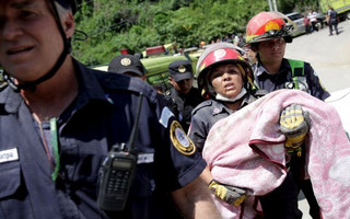 ATTENTION EDITORS - VISUAL COVERAGE OF SCENES OF INJURY OR DEATHA firefighter carries the body of a child retrieved from a mudslide in Santa Catarina Pinula, on the outskirts of Guatemala City, October 2, 2015. The collapse of a hillside onto a town on the edge of Guatemala City killed at least 26 people and left hundreds missing on Friday, as rescue crews desperately searched for survivors in homes buried by dirt and sludge. Loosened by heavy rains, tons of dirt and trees tumbled onto Santa Catarina Pinula in a valley on the southeastern flank of the capital late on Thursday, flattening dozens of flimsy houses when many residents had gone home for the night. REUTERS/Josue Decavele
