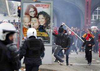 A demonstrator smashes an advertising panel during clashes at a march against government reforms and cost-cutting measures in Brussels , October 7, 2015.    REUTERS/Yves Herman