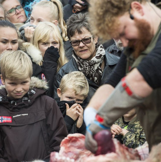 People watch as a lion is dissected at Odense Zoo in Odense, Denmark