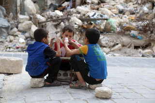 Boys play cards in front of the rubble of damaged buildings, in the old city of Aleppo, Syria October 18, 2015. REUTERS/Hosam Katan  EDITORIAL USE ONLY. NO RESALES. NO ARCHIVE