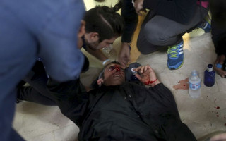 A protester is attended after being hit by a rubber bullet shot by Spanish National Police near the Ramon Llull school assigned to be a polling station by the Catalan government in Barcelona, Spain, early Sunday, 1 Oct. 2017. The Spanish government and its security forces are trying to prevent voting in the independence referendum, which is backed by Catalan regional authorities. Spanish officials had said force wouldn't be used, but that voting wouldn't be allowed. (AP Photo/Manu Brabo)