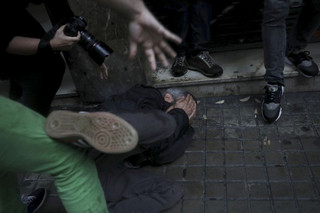 A protester falls on the ground after being hit in the face by a rubber bullet shot by Spanish National Police near the Ramon Llull school assigned to be a polling station by the Catalan government in Barcelona, Spain, early Sunday, 1 Oct. 2017. The Spanish government and its security forces are trying to prevent voting in the independence referendum, which is backed by Catalan regional authorities. Spanish officials had said force wouldn't be used, but that voting wouldn't be allowed. (AP Photo/Manu Brabo)