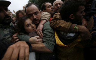 Pro-referendum supporters embrace each other as Spanish National Police tries to remove them from the Ramon Llull school assigned to be a polling station by the Catalan government in Barcelona, Spain, early Sunday, 1 Oct. 2017. Catalan pro-referendum supporters vowed to ignore a police ultimatum to leave the schools they are occupying to use in a vote seeking independence from Spain. (AP Photo/Emilio Morenatti)