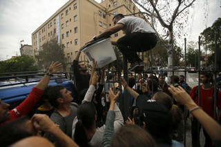 A ballot box is taken from a school assigned to be a referendum polling station by the Catalan government in Girona, Spain, Sunday, Oct. 1, 2017. Ballot boxes where taken to be stored temporarily in a safe place in case the police storms the school. The Spanish government and its security forces are trying to prevent voting in the independence referendum, which is backed by Catalan regional authorities. (AP Photo/Francisco Seco)