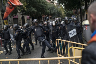 Spanish riot police removes fences thrown by people to them as they try to prevent people from reaching a voting site at a school assigned to be a polling station by the Catalan government in Barcelona, Spain, Sunday, 1 Oct. 2017. Catalan pro-referendum supporters vowed Saturday to ignore a police ultimatum to leave the schools they are occupying to use in a vote seeking independence from Spain. (AP Photo/Felipe Dana)