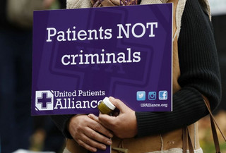 A demonstrator holds a banner during a rally in London, Tuesday, Oct. 10, 2017. The rally was to help raise awareness of the medical use of cannabis. (AP Photo/Kirsty Wigglesworth)