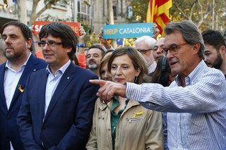 Former Catalan President Artur Mas, right, points next to Catalan deputy president Oriol Junqueras, left, President Carles Puigdemont, 2nd left and Carme Forcadell, speaker of the house in the Catalan parliament during a protest against the National Court's decision to imprison civil society leaders, in Barcelona, Spain, Saturday, Oct. 21, 2017. The Spanish government moved decisively Saturday to use a previously untapped constitutional power so it can take control of Catalonia and derail the independence movement led by separatist politicians in the prosperous industrial region. (AP Photo/Manu Fernandez)