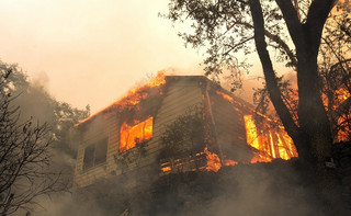 Flames from a massive wildfire consume a home on the Silverado Trail, Monday, Oct. 9, 2017, east of Napa, Calif. (AP Photo/Rich Pedroncelli) Flames from a massive wildfire consume a home on the Silverado Trail, Monday, Oct. 9, 2017, east of Napa, Calif. (AP Photo/Rich Pedroncelli)