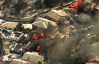 In this image made from a video provided by KABC-TV, a fire burns in the Anaheim Hills area of Anaheim, Calif., in northern Orange County in Southern California on Monday, Oct. 9, 2017. Wildfires whipped by powerful winds swept through Northern California sending residents on a headlong flight to safety through smoke and flames as homes burned. (KABC-TV via AP)