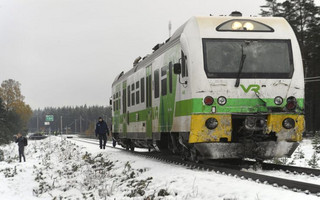 A police officer walks alongside a train that was involved in a crash with a military truck in which several people were killed in southern Finland Thursday Oct. 26, 2017.  Finnish media say several people have been killed in a train crash in the southern part of Finland. (Lehtikuva via AP)