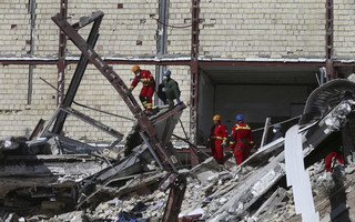 Rescuers work on the debris on the earthquake site in Sarpol-e-Zahab in western Iran, Tuesday, Nov. 14, 2017. Rescuers are digging through the debris of buildings felled by the Sunday earthquake in the border region of Iran and Iraq. (AP Photo/Vahid Salemi)