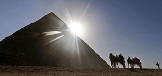 FILE - In this Wednesday, Dec. 12, 2012 file photo, Tourists ride in horse carriages past one of the Great Pyramids in Giza, Egypt. The past month saw a drop in tourists to Egypt, scared off by scenes of protests and clashes over the constitution, in new pain to a crucial industry gutted the past two years by turmoil. Tourism workers worry things wont get any better even now that the charter has been passed: Egypts power struggles threaten to erupt into more unrest at any time, and some fear Islamists will eventually try to rein in alcohol and beach tourism.  (AP Photo/Petr David Josek, File)