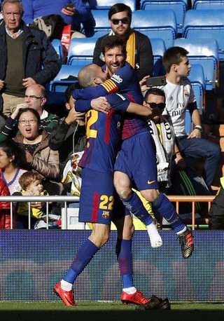 Barcelona's Aleix Vidal celebrates with Lionel Messi, right, after scoring his side's third goal during the Spanish La Liga soccer match between Real Madrid and Barcelona at the Santiago Bernabeu stadium in Madrid, Spain, Saturday, Dec. 23, 2017. (AP Photo/Francisco Seco)