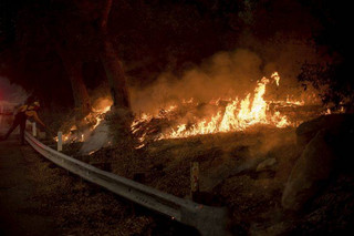 Firefighter Joe Santos of Nevada works to contain the Thomas fire burning through Los Padres National Forest near Ojai, Calif., on Friday, Dec. 8, 2017. (AP Photo/Noah Berger)