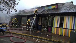 In this handout photo provided by the London Fire Brigade, firefighters work at the scene at Adventure cafe and shop near the Meerkat enclosure at London Zoo, London, Saturday, Dec. 23, 2017. London Zoo officials say a fire that broke out before the facility opened Saturday morning left one aardvark dead and four meerkats missing and presumed dead. Staff members were treated for smoke inhalation and shock after the blaze broke out near the zoo cafe in the early morning hours. (London Fire Brigade via AP)