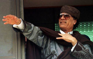 Libyan President Moammar Gaddafi acknowledges a crowd that gathered outside the governor's office to greet him in Marsa Matruh, Egypt, about 400 km (250 miles) northwest of Cairo Friday, March 5, 1999. Gaddafi will meet Egyptian President Hosni Mubarak on the proposed hand-over of the Lockerbie bombing suspects for trial. Gaddafi has long refused to turn over the suspects, who have been indicted in Scotland and the United States, for the blowing up of an American airliner over the Scottish town of Lockerbie in 1988. The bombing killed 270 people, mainly Britons and Americans. (AP Photo/Enric Marti)