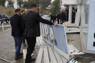 Police officers observe a wracked sign of the Afrika newspaper office after it was attacked by supporters of the Turkish President Recep Tayyip Erdogan in the Turkish occupied norther part of the divided capital Nicosia, Cyprus, Monday, Jan. 22, 2018.  Editor of afrika, Sener Levent alleged during an interview with The Associated Press that Monday's attack was prompted by Turkish President Recep Tayyip Erdogan. (AP Photo/Petros Karadjias)