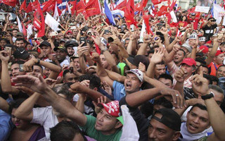 Opposition supporters cheer during a rally where Salvador Nasralla reaffirmed his claim on the presidency of Honduras, in the central park of San Pedro Sula, Honduras, Saturday, Jan. 6, 2018. Following a disputed election marred by irregularities, incumbent Juan Orlando Hernandez was declared the victor and will be inaugurated on Jan. 27. At a march and rally that drew thousands, Nasralla said he would not stop calling for protests and civil disobedience until Hernandez agrees to step down. (AP Photo/Fernando Antonio)