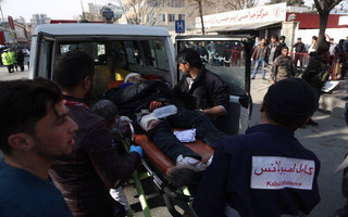 A wounded man is assisted to a hospital following a deadly suicide attack in the center of Kabul, Afghanistan, Saturday, Jan. 27, 2018. Afghan Public Health Ministry says dozens have been killed and over 100 wounded in suicide car bomb attack in capital Kabul. (AP Photo/Massoud Hossaini)