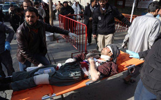 People help carry an injured man to the hospital following a suicide attack in Kabul, Afghanistan, Saturday Jan. 27, 2017. The Public Health Ministry says over a dozen were killed, and over 100 wounded ina suicide car bombing in downtown Kabul. (AP Photo/ Rahmat Gul)
