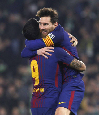 Barcelona's Messi, right, celebrates with teammate Suarez after scoring against Betis during the La Liga soccer match between Barcelona and Betis at the Villamarin stadium, in Seville, Spain on Sunday, Jan. 21, 2018. (AP Photo/Miguel Morenatti)