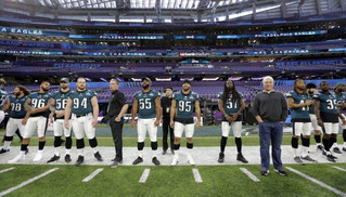 Philadelphia Eagles owner Jeffrey Lurie, front right, stands with players as they prepare for a walk through for the NFL Super Bowl 52 football game at U.S. Bank Stadium, Saturday, Feb. 3, 2018, in Minneapolis. Philadelphia is scheduled to face the New England Patriots Sunday. (AP Photo/Eric Gay)