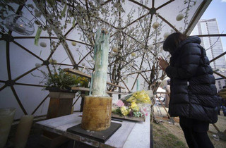 A woman prays to mourn for victims of the March 11, 2011 earthquake and tsunami prior to a special memorial event in Tokyo Sunday, March 11, 2018. Japan on Sunday marked the seventh anniversary of the 2011 tsunami that killed more than 18,000 people and left a devastated coastline along the country's northeast that has still not been fully rebuilt. (AP Photo/Eugene Hoshiko)