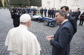 Pope Francis is flanked by Formula E CEO Alejandro Agag before blessing the Formula E electric official car, at the Vatican, Wednesday, April 11, 2018. A Formula E race will be held in Rome EUR district, Saturday, April 14. (Vatican Media via AP)