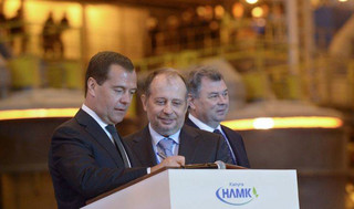 Russian Prime Minister Dmitry Medvedev, left, signs a book of guests at a newly opened metallurgical plant NLMK - Kaluga, at Maloyaroslavets,  about 150 km ( 93 miles) south-west of Moscow on Tuesday, July 23, 2013.  Kaluga region governor Anatoly Artamonov, right, and NLMK-Kaluga plant director Vladimir Lisin, center, look on. (AP Photo / RIA Novosti, Alexander Astafyev, Government Press Service)
