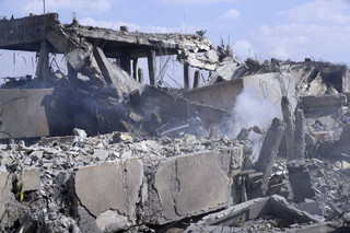 A fireman extinguishes smoke that rises from the damage of the Syrian Scientific Research Center which was attacked by U.S., British and French military strikes to punish President Bashar Assad for suspected chemical attack against civilians, in Barzeh, near Damascus, Syria, Saturday, April 14, 2018. The Pentagon says none of the missiles filed by the U.S. and its allies was deflected by Syrian air defenses, rebutting claims by the Russian and Syrian governments. Lt. Gen. Kenneth McKenzie, the director of the Joint Staff at the Pentagon, also says there also is no indication that Russian air defense systems were employed early Saturday in Syria. (AP Photo/Hassan Ammar)