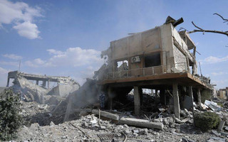 A fireman extinguishes smoke that rises from the damage of the Syrian Scientific Research Center which was attacked by U.S., British and French military strikes to punish President Bashar Assad for suspected chemical attack against civilians, in Barzeh, near Damascus, Syria, Saturday, April 14, 2018. The Pentagon says none of the missiles filed by the U.S. and its allies was deflected by Syrian air defenses, rebutting claims by the Russian and Syrian governments. Lt. Gen. Kenneth McKenzie, the director of the Joint Staff at the Pentagon, also says there also is no indication that Russian air defense systems were employed early Saturday in Syria. (AP Photo/Hassan Ammar)