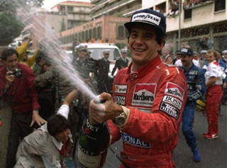 Brazilian driver Ayrton Senna sprays champagne on the photographers to celebrate his career's 30th victory at the Monaco Formula One Grand Prix May 12, 1990.  Britain's Nigel Mansell, who placed second, is visible at right.  (AP Photo/Lionel Cironneau)