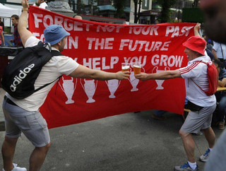 Liverpool supporters toast as they hold up a banner at a fan-zone in Kiev, Ukraine, Friday, May 25, 2018 ahead of Saturday's Champions League soccer match final between Real Madrid and Liverpool. (AP Photo/Sergei Grits)