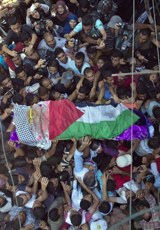 Palestinian mourners carry the body of a volunteer paramedic Razan Najjar, 21, into her family house during her funeral in town of Khan Younis, southern Gaza Strip, Saturday, June 2, 2018. Najjar was killed by Israeli fire Friday during mass protests in the Gaza Strip, the Palestinian Health Ministry said. (AP Photo/Khalil Hamra)