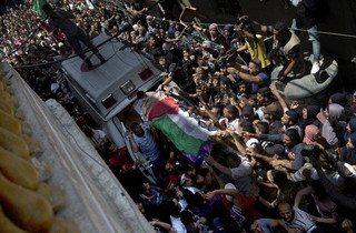 Palestinian mourners carry the body of a volunteer paramedic Razan Najjar, 21, into her family house during her funeral in town of Khan Younis, southern Gaza Strip, Saturday, June 2, 2018. Najjar was killed by Israeli fire Friday during mass protests in the Gaza Strip, the Palestinian Health Ministry said. (AP Photo/Khalil Hamra)