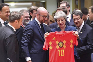 British Prime Minister Theresa May, center right, holds up a Belgian National team soccer jersey presented by Belgian Prime Minister Charles Michel, center left, during a round table meeting at an EU summit in Brussels, Thursday, June 28, 2018. European Union leaders meet for a two-day summit to address the political crisis over migration and discuss how to proceed on the Brexit negotiations. (AP Photo/Geert Vanden Wijngaert)