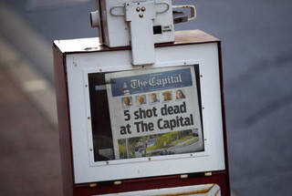 A Capital Gazette newspaper rack displays the day's front page, Friday, June 29, 2018, in Annapolis, Md. A man armed with smoke grenades and a shotgun attacked journalists in the newspaper's building Thursday, killing several people before police quickly stormed the building and arrested him, police and witnesses said. (AP Photo/Patrick Semansky)