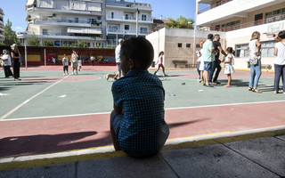 Παιδί κάθεται στην αυλή του σχολείου Παιδί κάθεται στην αυλή του σχολείου