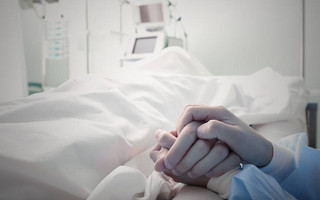 Συνοδός κρατάει το χέρι ασθενούς σε νοσοκομείο