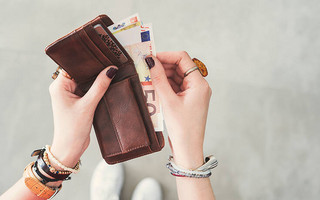 Γυναίκα κρατά πορτοφόλι με χρήματα μέσα σε αυτό Γυναίκα κρατά πορτοφόλι με χρήματα μέσα σε αυτό
