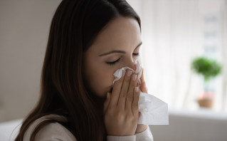 Γυναίκα με γρίπη, φυσάει τη μύτη της
