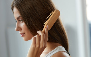 Γυναίκα βουρτσίζει τα μαλλιά της