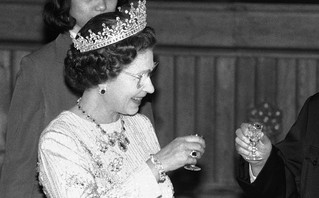Queen Elizabeth smiling with a drink in her hand