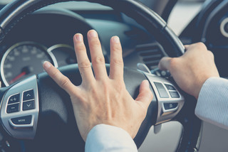 Driver hand on car horn