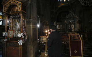 Πιστός ανάβει κερί σε εκκλησία