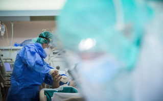 Νοσηλευτής κρατάει το χέρι ασθενούς με κορονοϊό