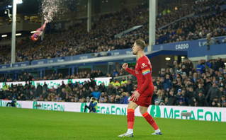 A bottle flies next to Henderson of Liverpool