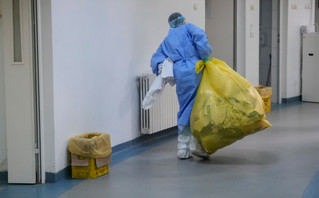 Υγειονομικός μεταφέρει σακούλα με απορρίμματα