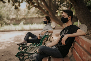 Men with masks on benches
