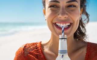 Γυναίκα πίνει νερό σε παραλία